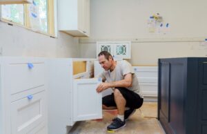 Parent installing cabinet safety locks in a kitchen to childproof the home.