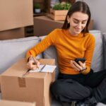 Homeowner creating a home inventory checklist using a smartphone and notebook.