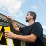 Homeowner inspecting gutters and roof as part of routine home maintenance.