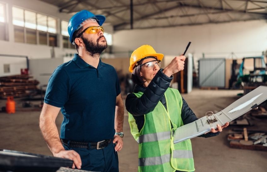 Small business owner conducting a workplace safety inspection with employees.