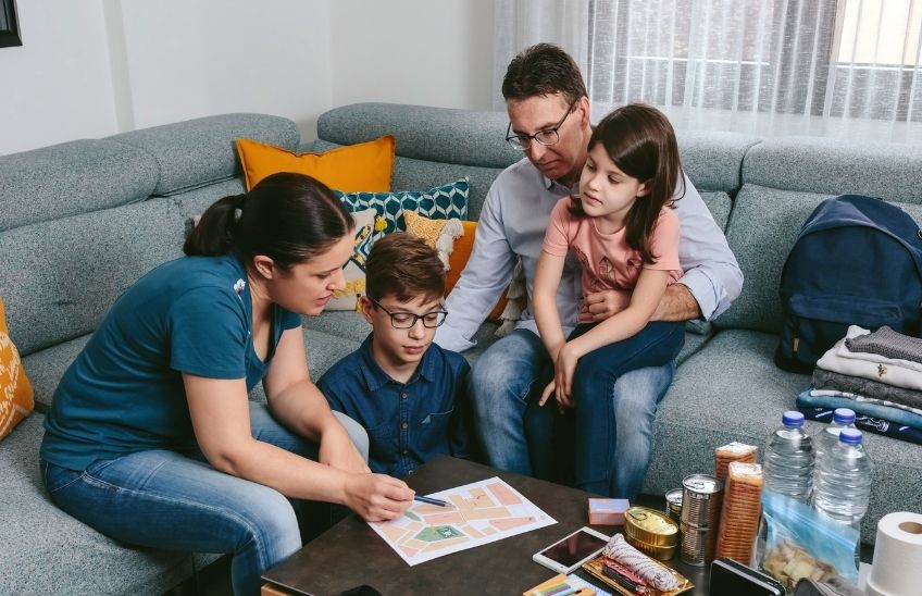 Family reviewing an emergency communication plan together at the kitchen table.