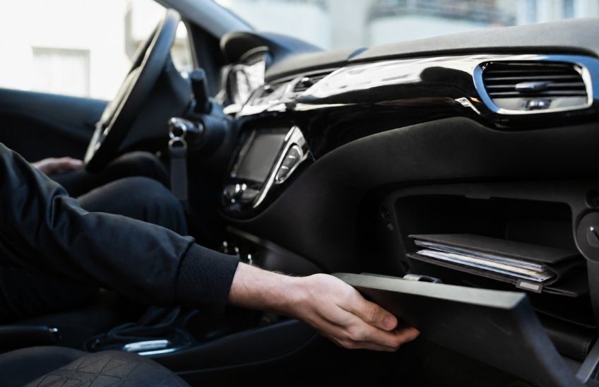 An organized glove compartment and essentials showing what to keep in your car.